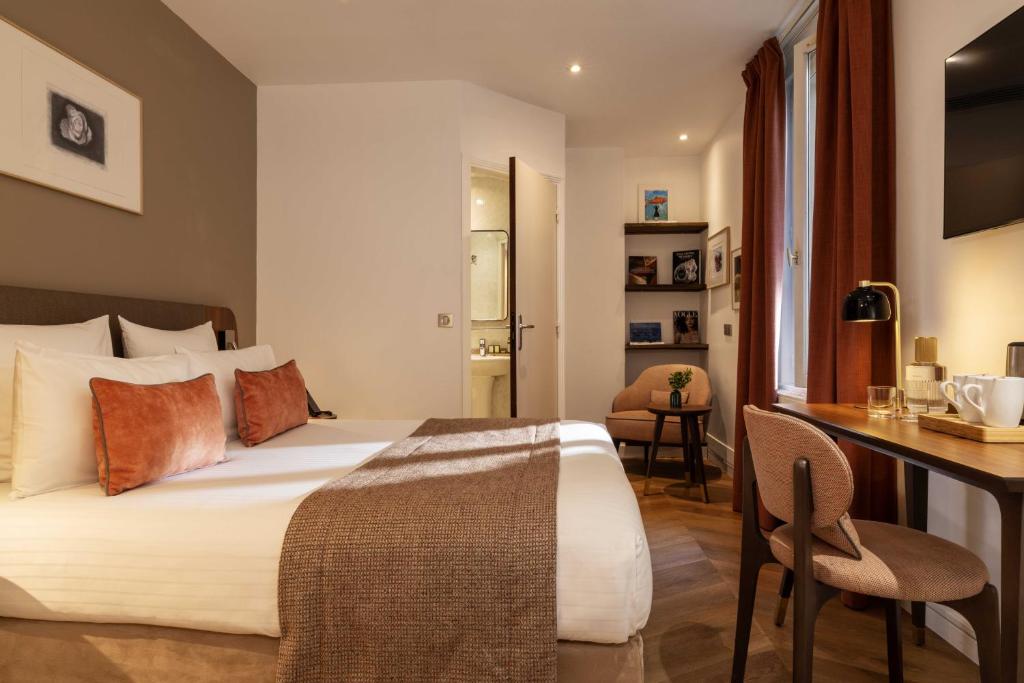 a hotel room with a bed and a desk and a desk at Europe Hotel Paris Eiffel in Paris