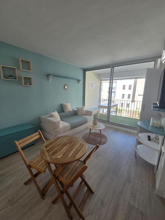 a living room with a couch and a table at La Parenthèse, studio in Gruissan