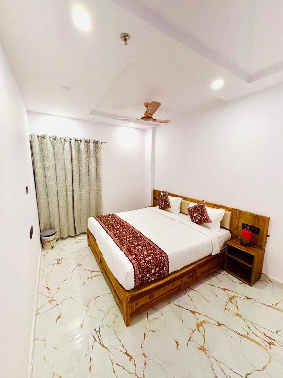 a bedroom with a bed with a marble floor at Hotel Shiva Darshanam in Varanasi