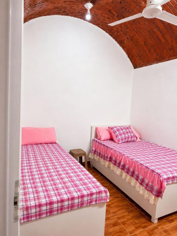 a bedroom with two beds and a ceiling fan at 2Sindbad camp in Al Karnak