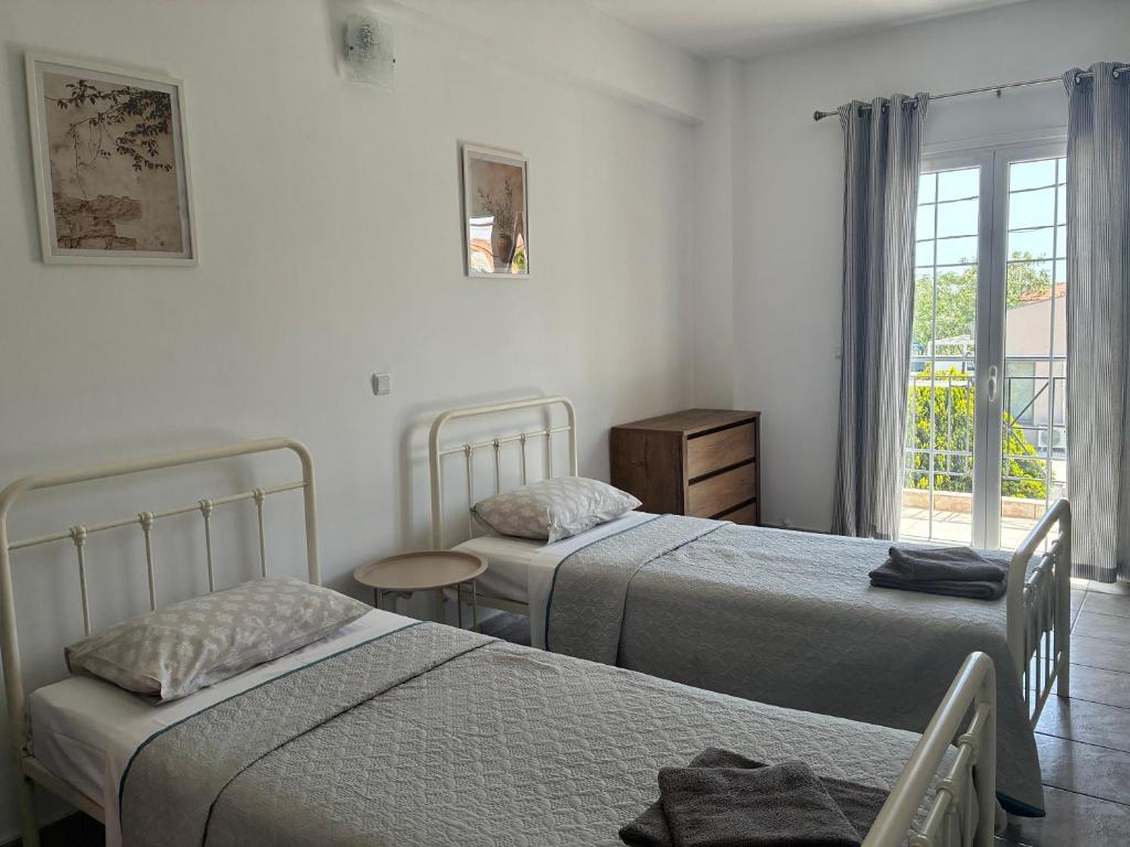 a bedroom with two beds and a window at Annalisa Studio & Apartments in Skala