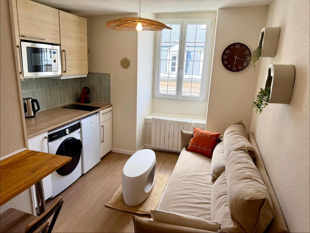 a living room with a couch and a kitchen at Le B - Appartement centre ville en duplex in Rennes