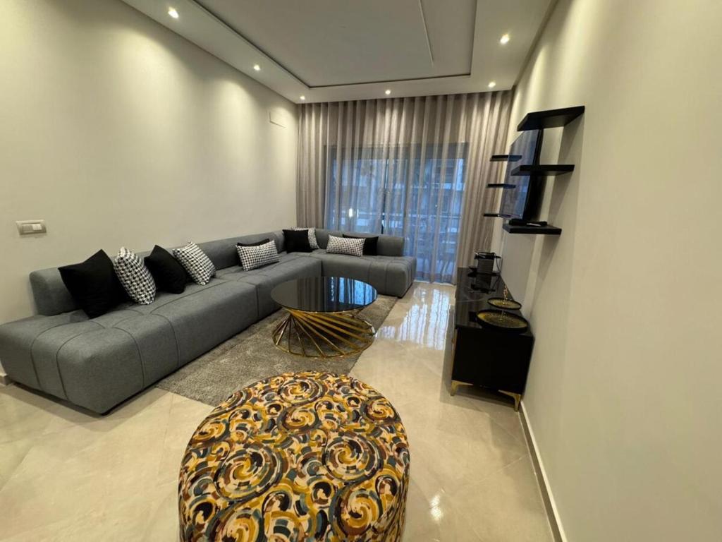 a living room with a couch and a table at Cozy apartment with pool view in Dar Hamida