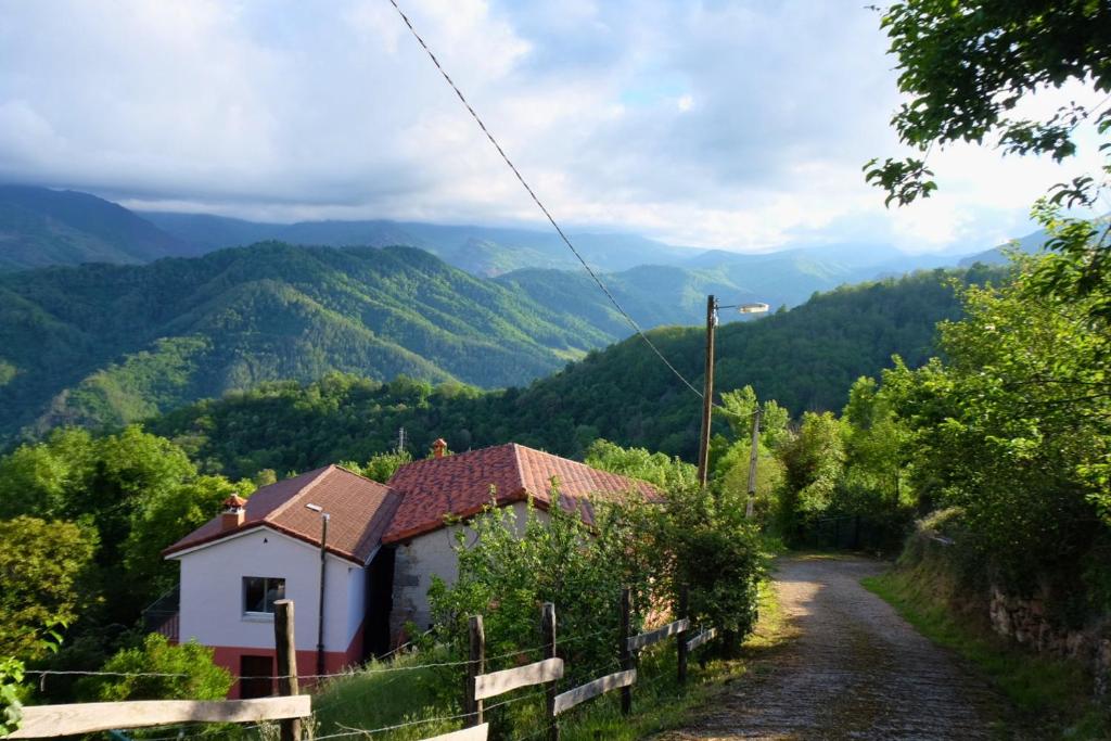 a small house on a road with mountains in the background at El Cimblu in Gradura