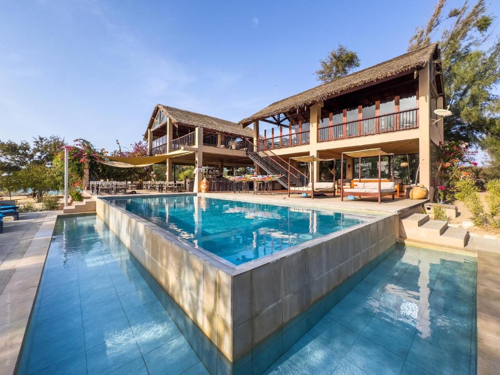a swimming pool in front of a house at Lodge Océan et Savane in Saint-Louis