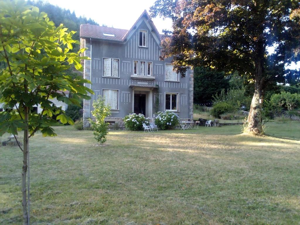 a large gray house with a tree in the yard at Villa Signerose - chambres chez l'habitant au cœur de l'Ardèche - Hautes vallées in Le Cheylard