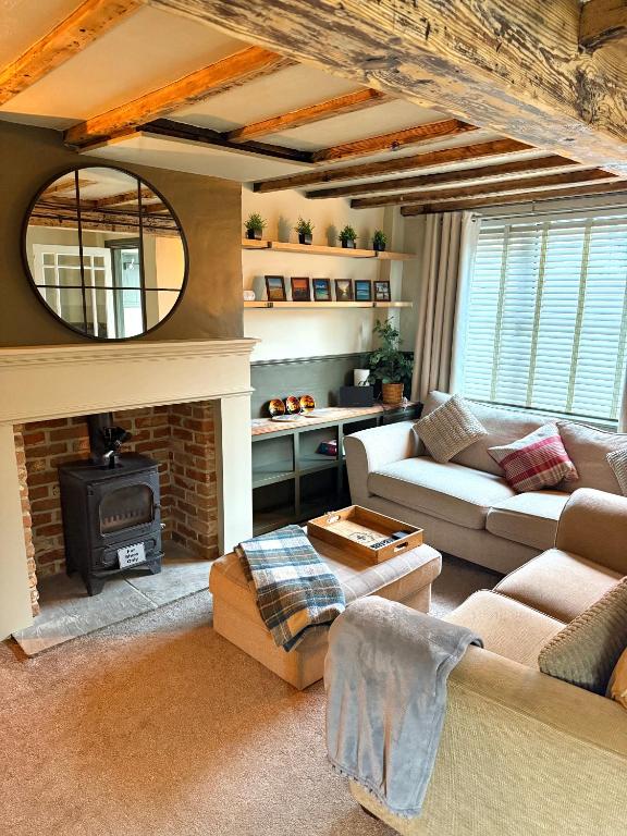 a living room with a couch and a fireplace at Rustic Retreat cottage in Thirsk