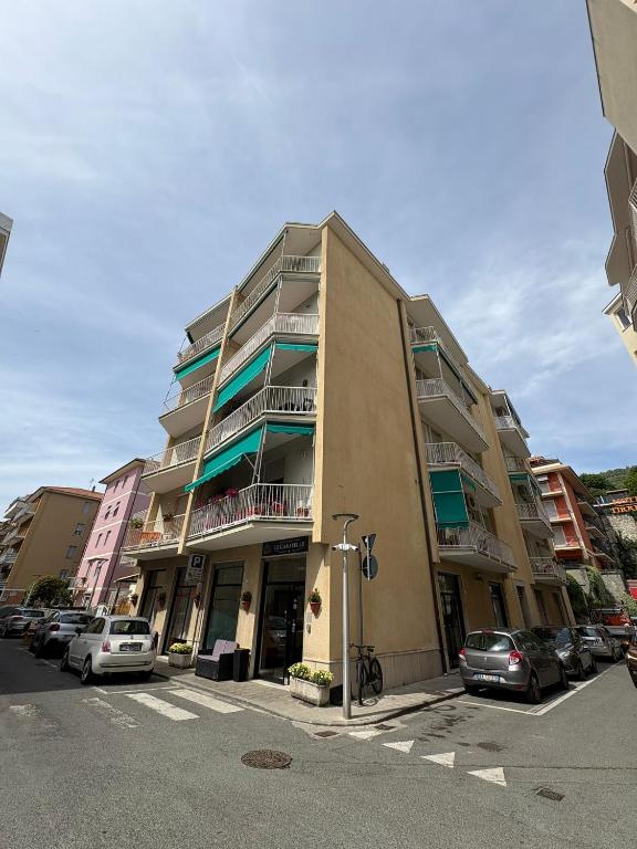 a tall building with cars parked in a parking lot at Hotel & Trattoria Le Caravelle in Lavagna