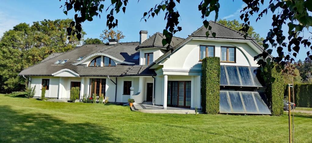 a white house with a gray roof at Willa Sielanka in Becejły