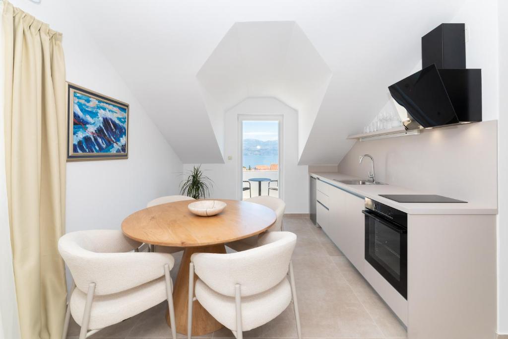 a kitchen with a wooden table and chairs in a kitchen at APARTMENTS JELENA 1,2,3,4 & 5 SUPETAR - free parking in Supetar
