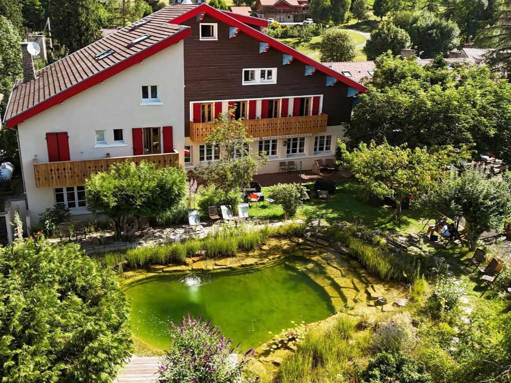 an aerial view of a house with a pond at Hôtel Bellier in La Chapelle-en-Vercors