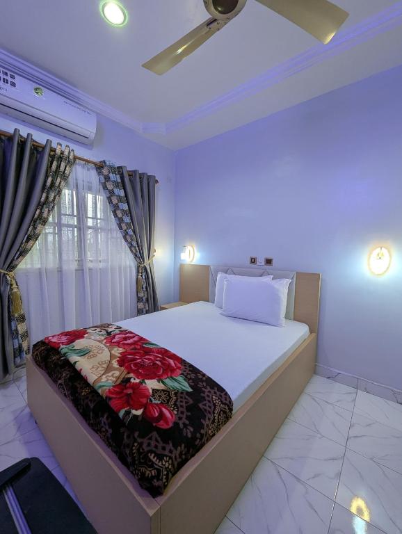 a bedroom with a large bed with a flower blanket on it at WAB STAR Lodge in Kumasi
