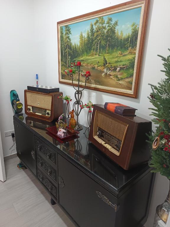 a black dresser with a painting on the wall at Aliki's Foini House in Phini