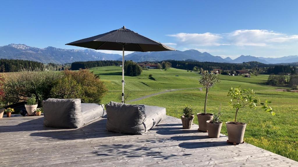 a patio with two couches and an umbrella at Chalet Bergblick in Rimsting