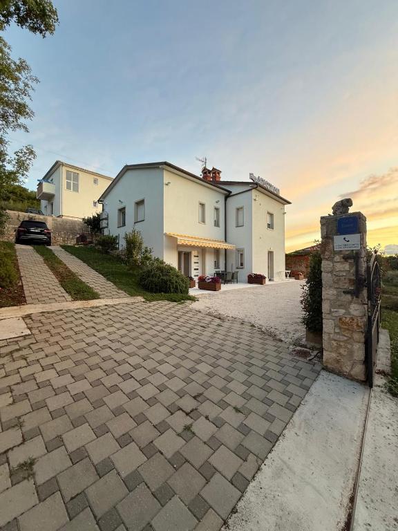 a house with a brick driveway in front of it at Appartament Tea in Šorići