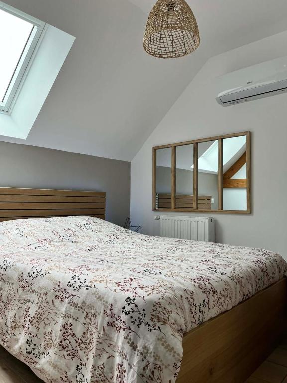 a bedroom with a bed with a floral bedspread at Séjour à la campagne - Logement cosy et chaleureux in Courgains