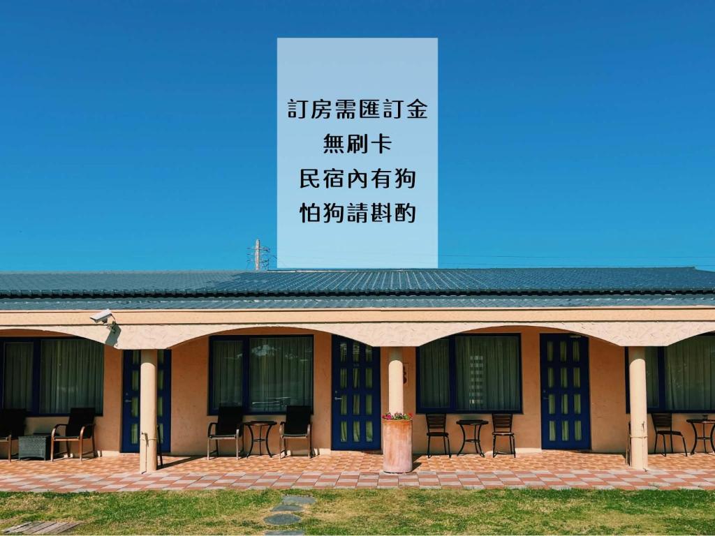a building with tables and chairs in front of it at Ding Jia Garden Resort in Hengchun South Gate