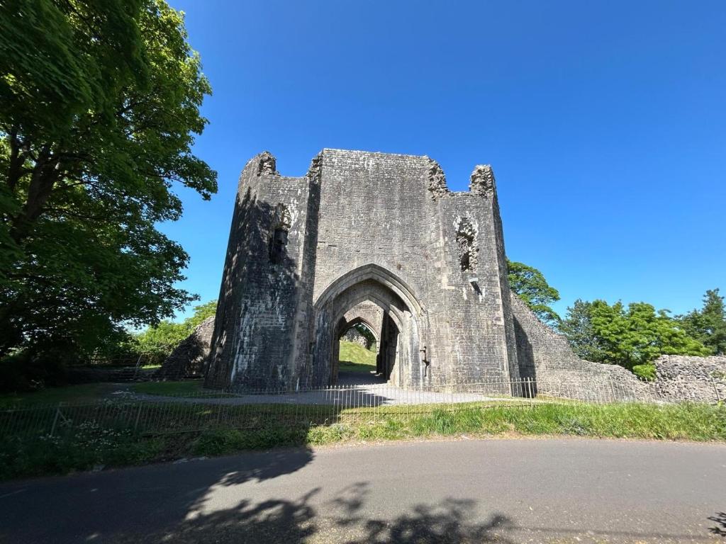 an old stone building with an arch in a park at Castle cottage in Cowbridge