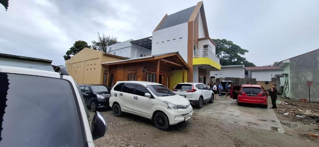 a group of cars parked in front of a building at Nok Homestay in Pangururan