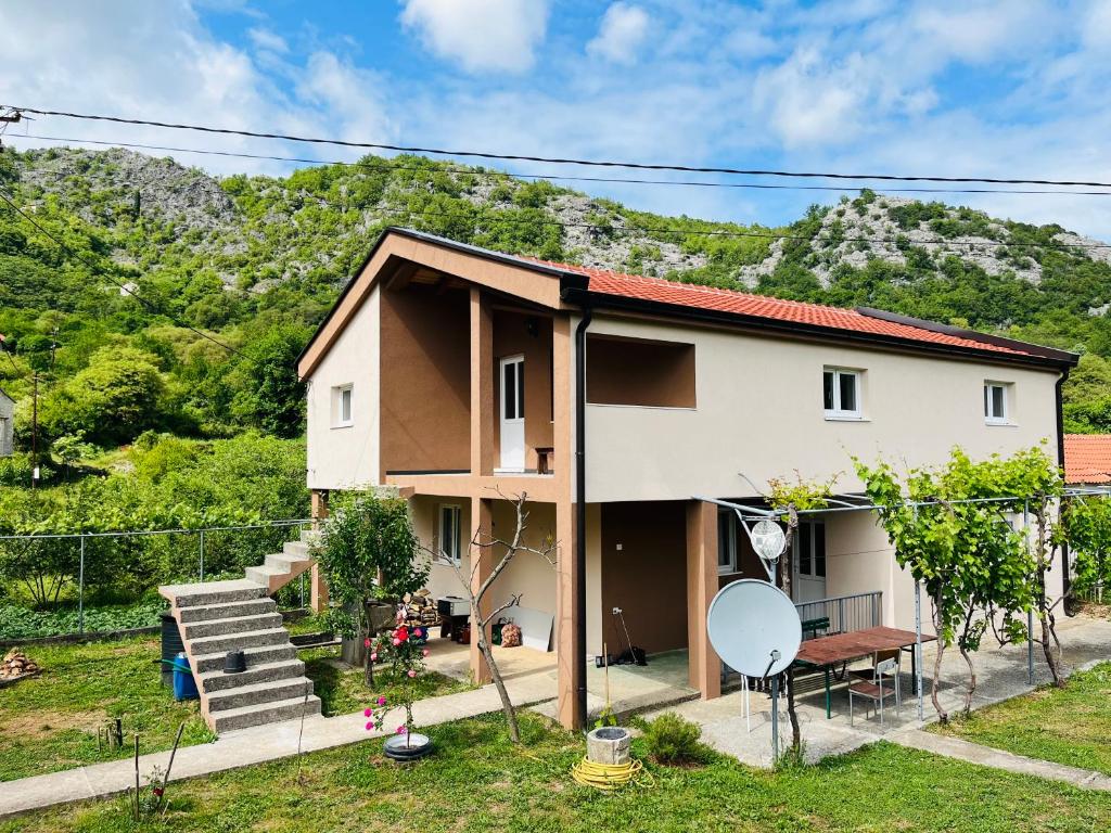 a house with a mountain in the background at Djekljak House in Virpazar