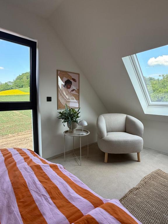 a bedroom with a bed and a chair and a window at Modernes Tinyhouse im Weserbergland nahe Hameln in Hessisch Oldendorf