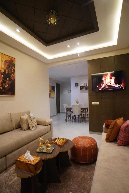 a living room with a couch and a tv at Chic Moderne avec Touche Marocaine in Kenitra