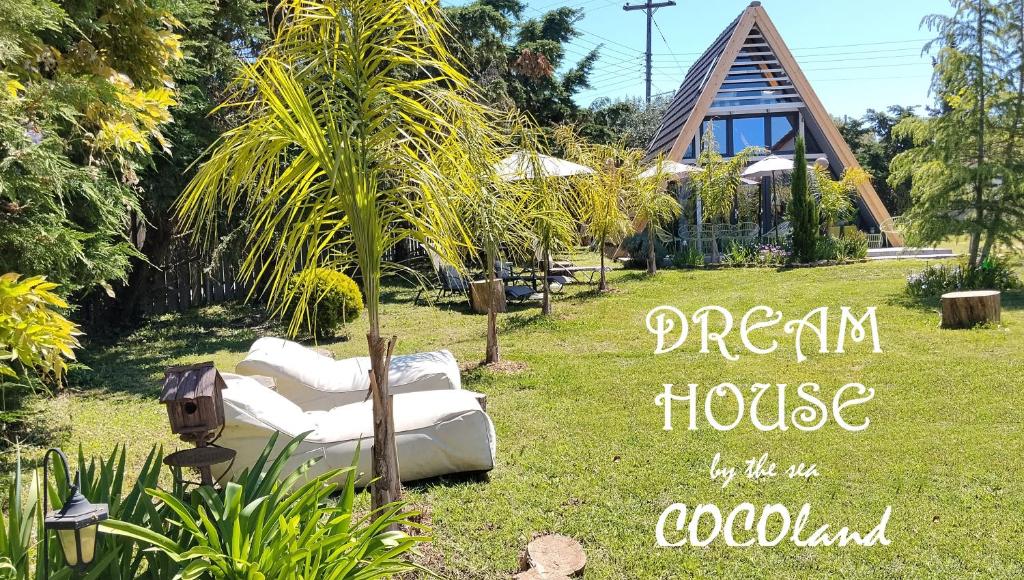 a garden house with a white couch in the grass at DREAM house by the sea in COCOland in Epanomi