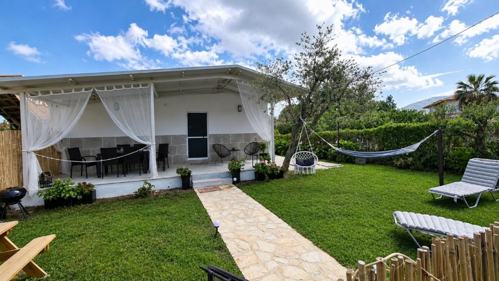 a house with a hammock in a yard at Olive holiday home in Laganas