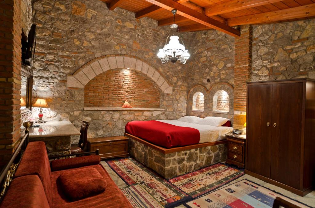 sypialnia z łóżkiem i kamienną ścianą w obiekcie Marianna w Nauplionie