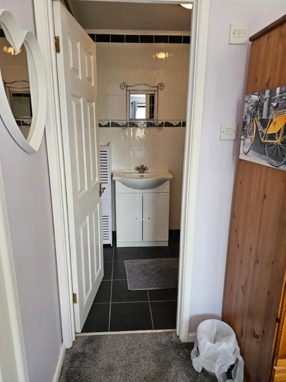 a small bathroom with a sink and a mirror at Quiet Room with ensuite in Chippenham