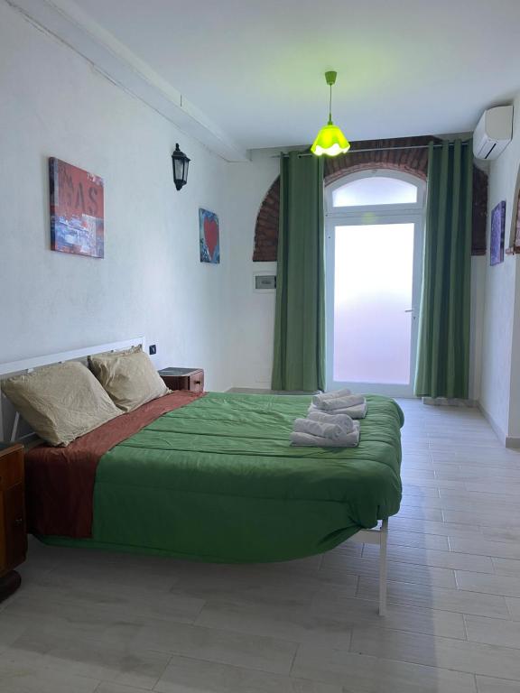 a bedroom with a green bed and a window at Home Ringo in Belvedere Marittimo