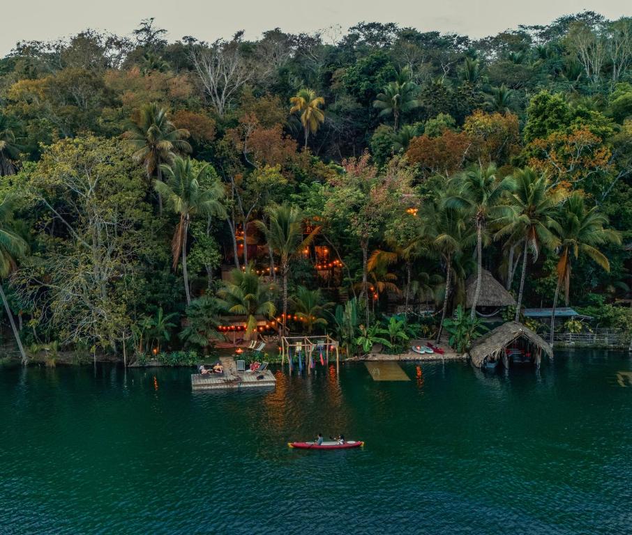 a resort with boats in the water and palm trees at Samaya Wellness Lodge in Flores