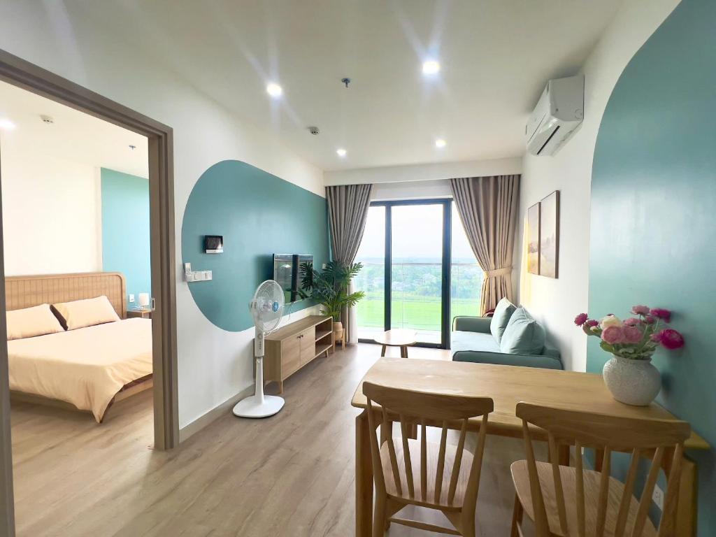 a bedroom with a bed and a table in a room at Beer Home Apartment - Huế Free Pool and Gym in Hue