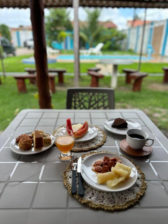 a table with plates of food and drinks on it at Pousada Villa Japa in Maragogi