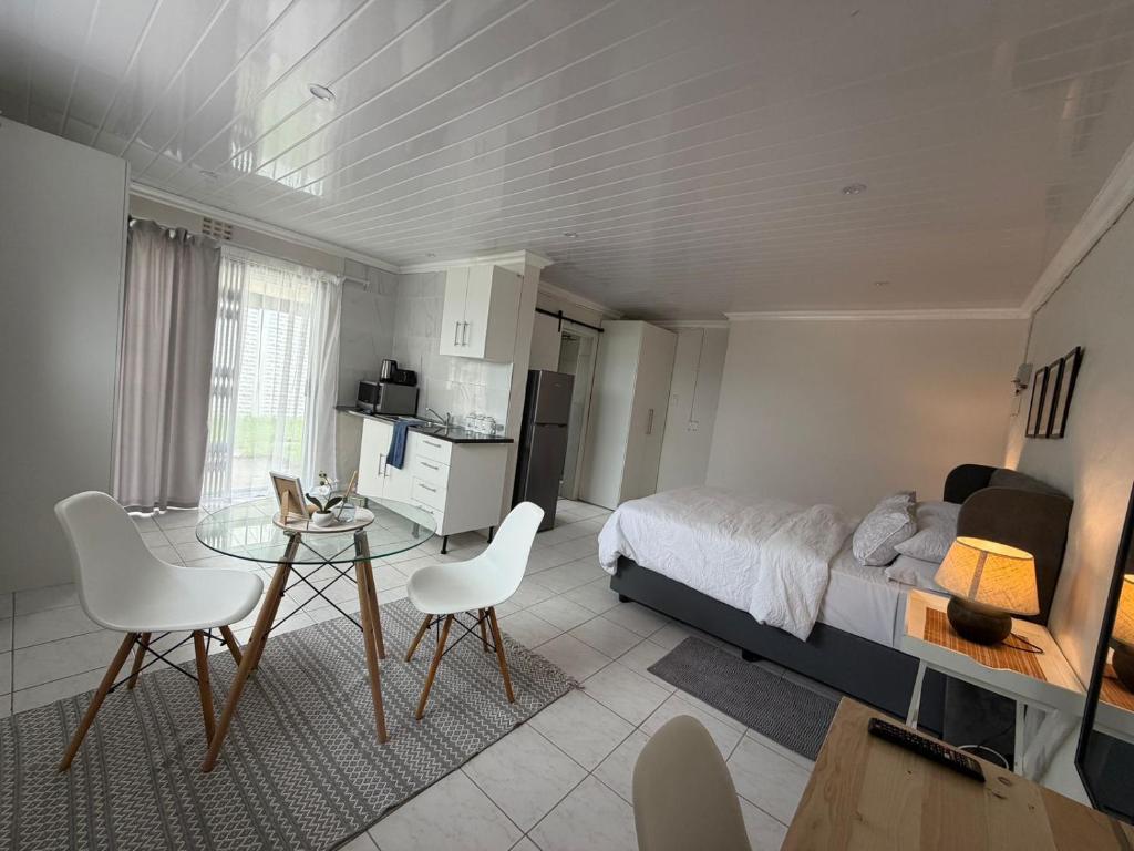 a bedroom with a bed and a table and chairs at The Ceed in Beacon Bay