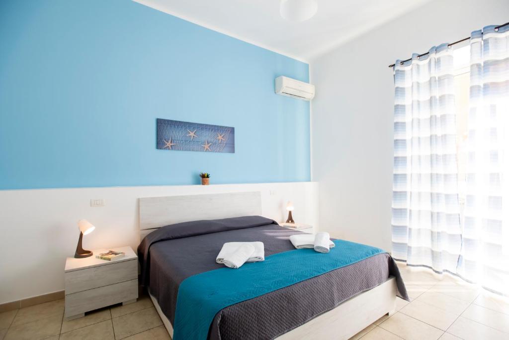 a bedroom with a bed and a blue ceiling at Pozzallo yellow house,5'dal mare in Pozzallo