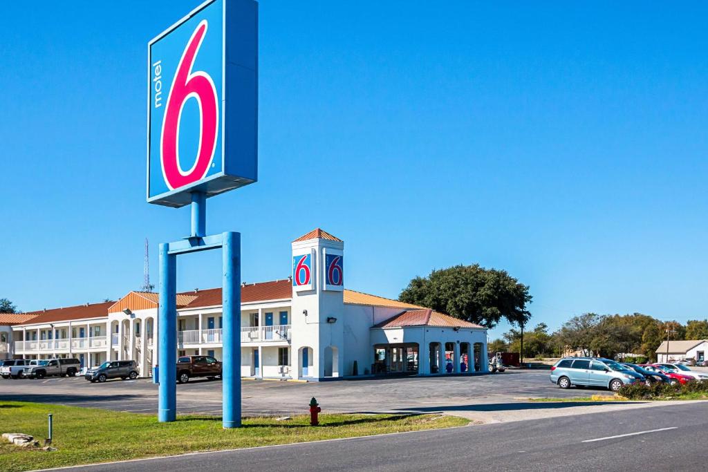 una señal frente a un edificio con aparcamiento en Motel 6-Round Rock, TX, en Round Rock