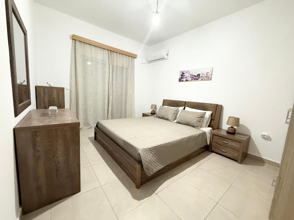a bedroom with a bed and a dresser and a window at Escape Rooms in Afantou