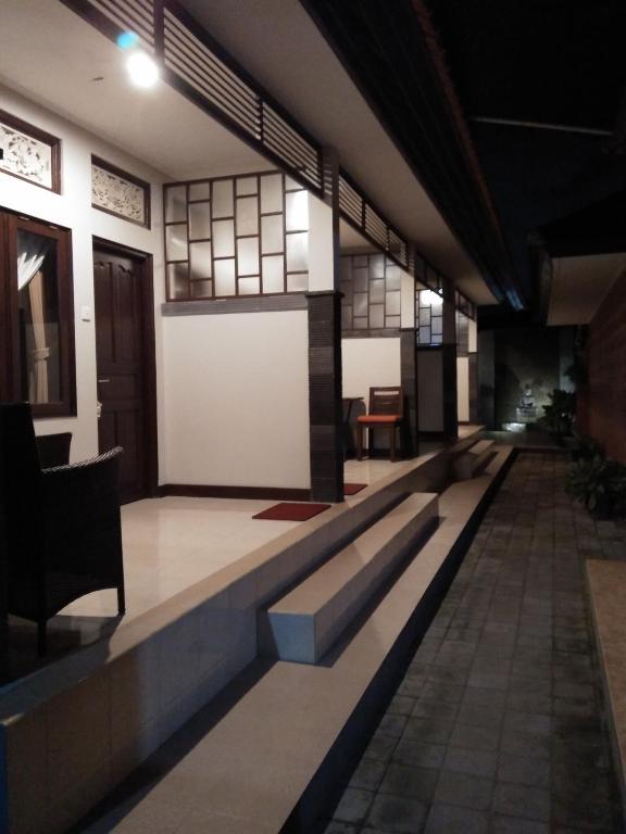 a long corridor in a building with a white wall at Buyan Homestay in Sanur