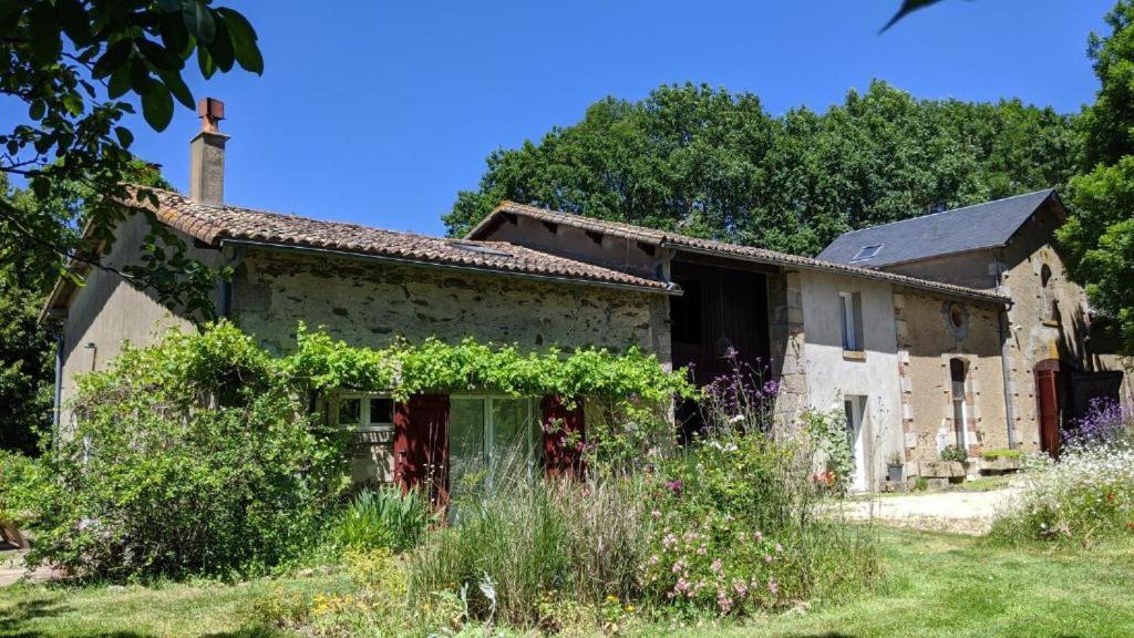 an old stone house with vines growing on it at L'Aveneau - Havre champêtre avec piscine d'été in Le Retail