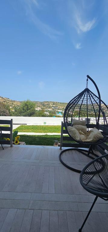 a swing sitting on a patio next to a bench at Alora House in Kefalos