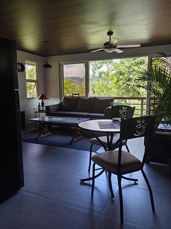 a living room with a couch and a table and chairs at Magnolia Farm Suites in San Isidro de El General