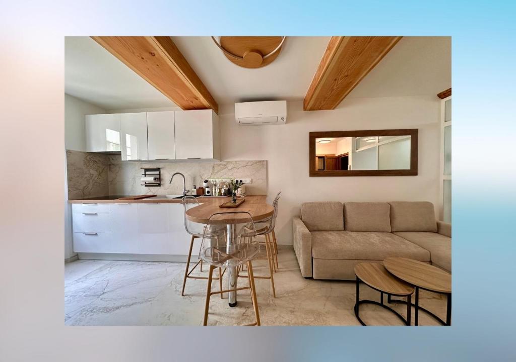 a kitchen and living room with a table and a couch at L'olivier du vieil Antibes in Antibes