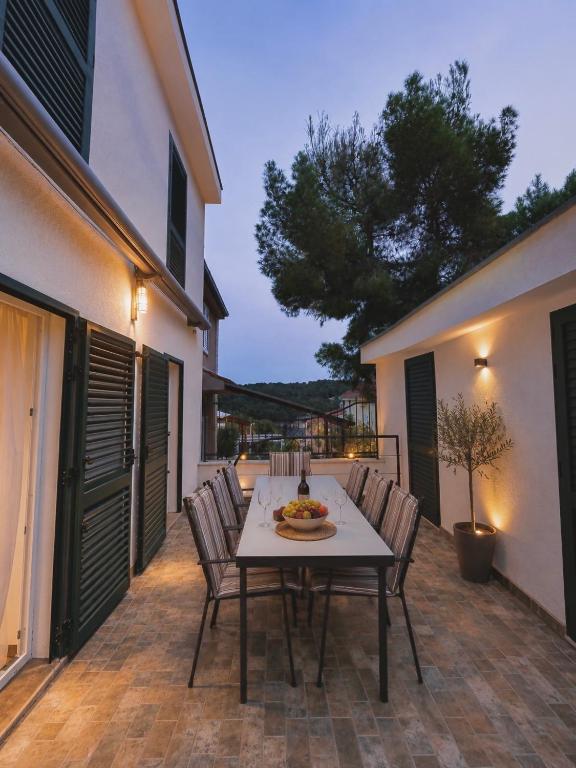 a patio with a table and chairs on a patio at Apartmani Kuic in Milna