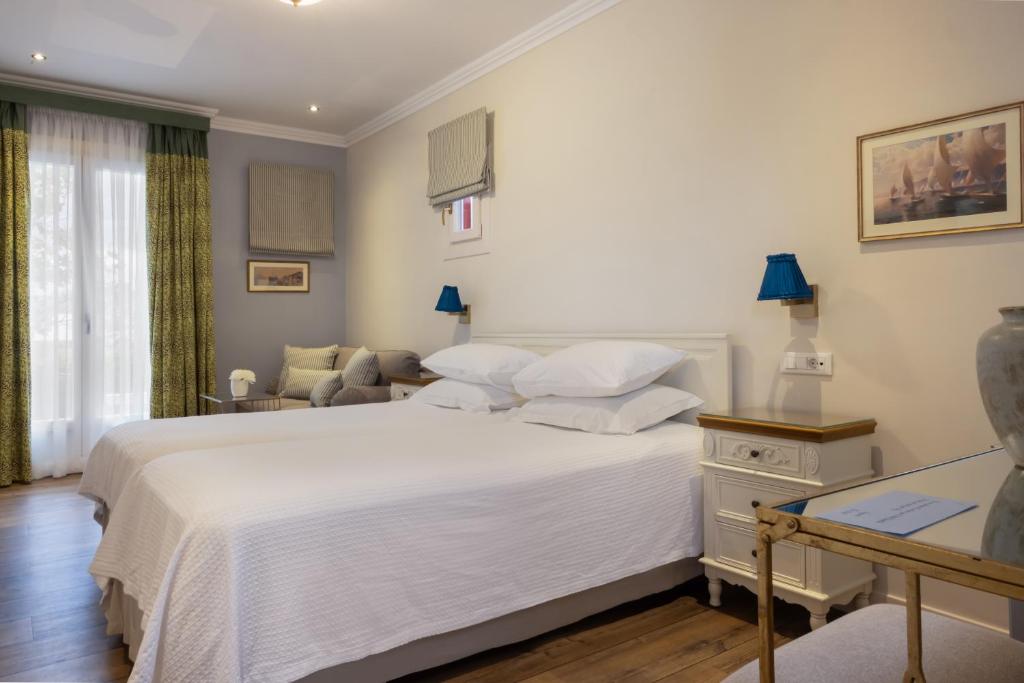 a bedroom with a white bed and a couch at Despotiko Hotel in Mikonos