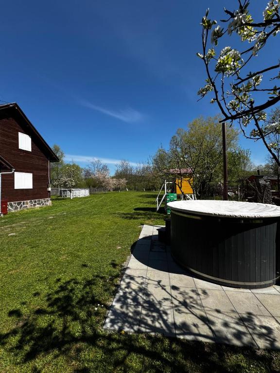eine große Wanne neben einem Grasfeld in der Unterkunft Vila ILKA in Praid