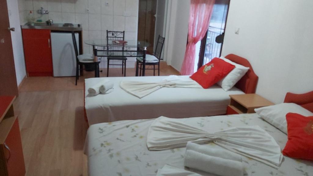 a room with two beds and a kitchen with a table at Apartmani Moco in Ulcinj
