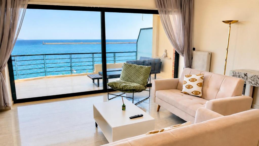 a living room with a couch and a view of the ocean at Seafront Luxury Apartment in Kalamata