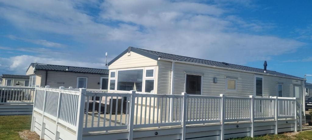 a house with a white fence in front of it at E21 The Sandy Heaven in Lossiemouth