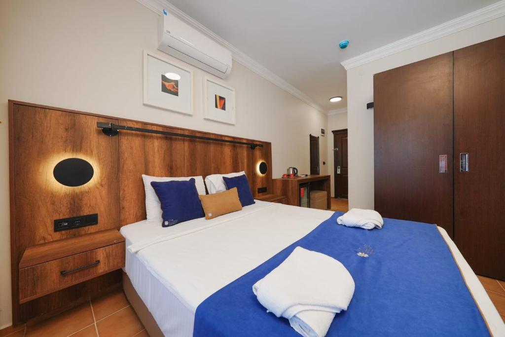 a bedroom with a large bed with blue and white pillows at Casa Lume in Bodrum City
